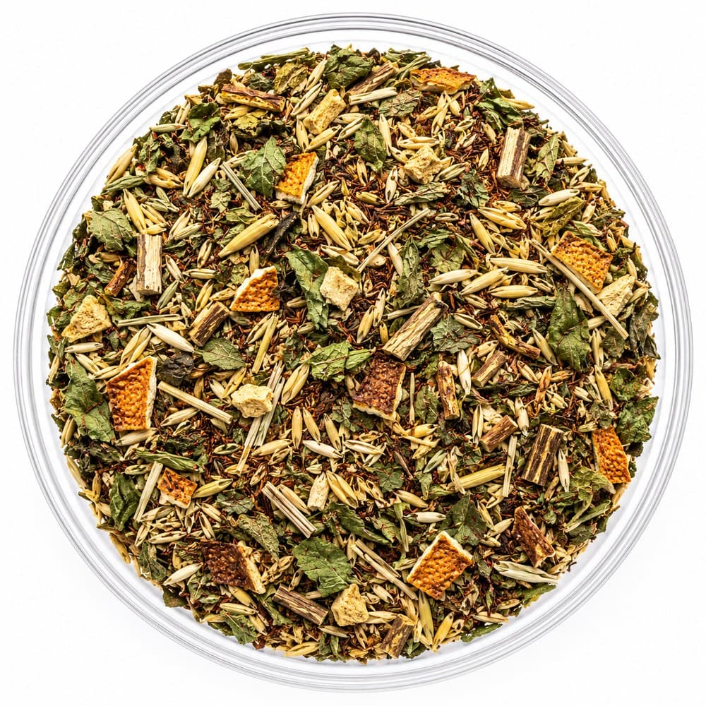 Baseline™ loose-leaf blend in a glass bowl — green leaf and oat tops with russet needles and squares of orange peel