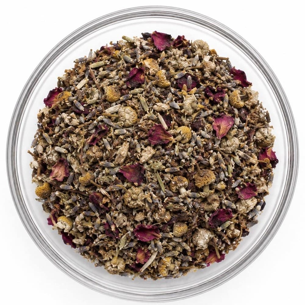 REST™ loose-leaf blend in a glass bowl — lavender buds, chamomile flowers and deep red rose petals
