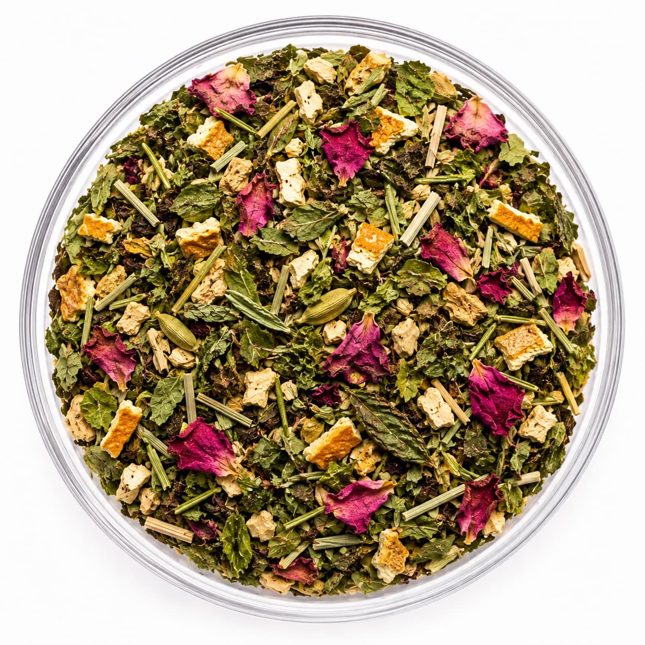 North Star™ loose-leaf blend in a glass bowl — green leaf and cut lemongrass with magenta rose petals, squares of orange peel and whole cardamom pods