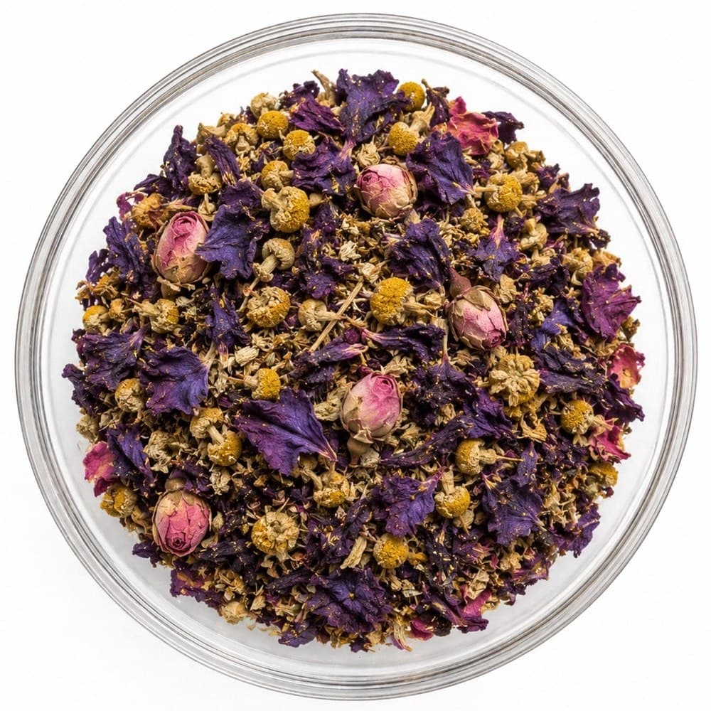 Peace, Remembered™ loose-leaf blend in a glass bowl — chamomile flowers, violet petals and pink rosebuds